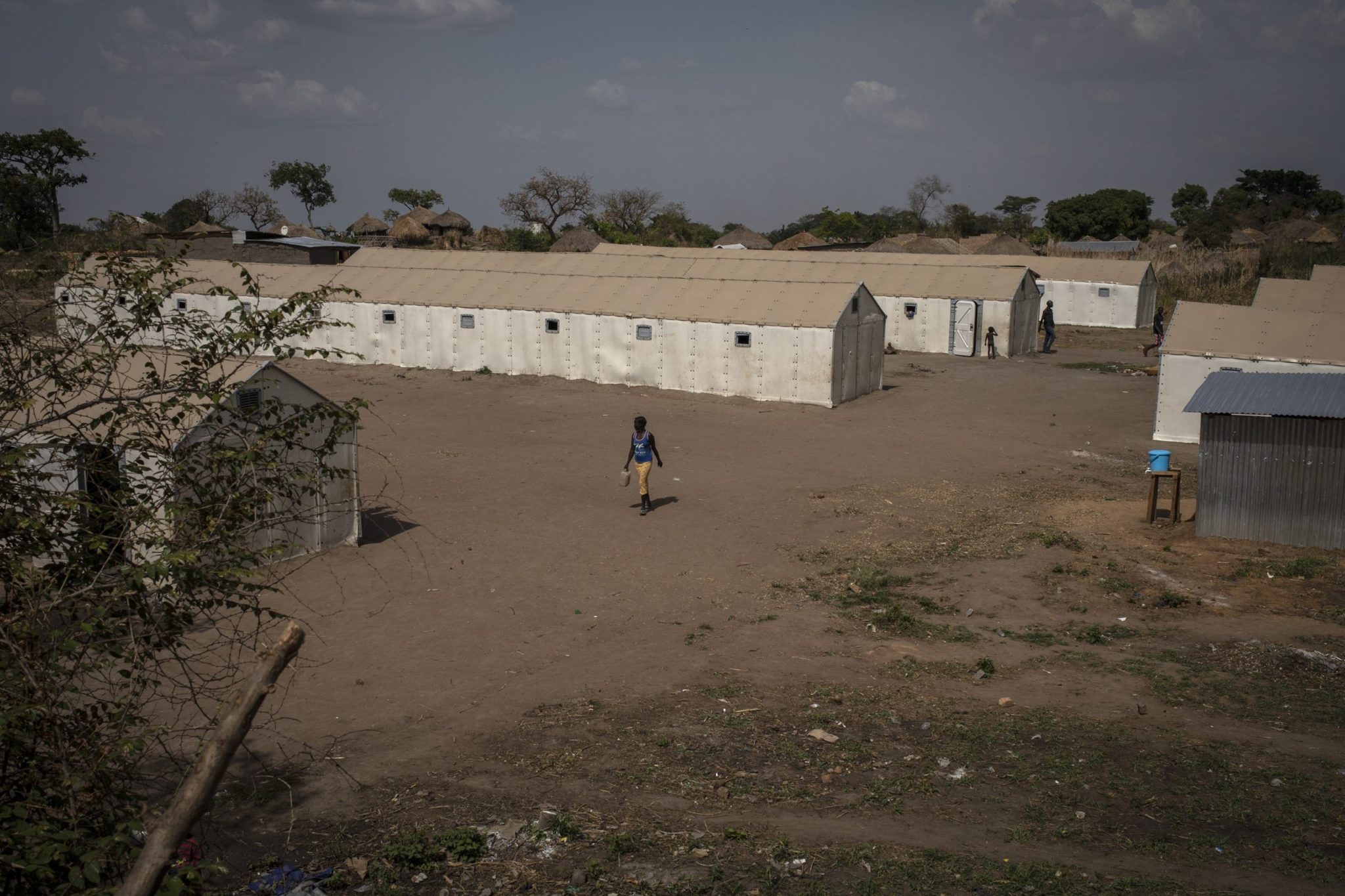 Democratic Republic of the Congo. A woman walks amongst tents for newly arrived refugees